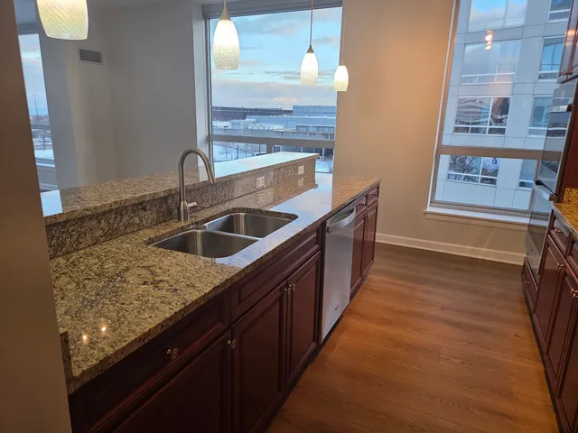 a kitchen with stainless steel appliances granite countertop a sink and a refrigerator