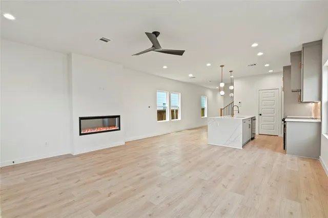 a view of a big room with wooden floor and windows