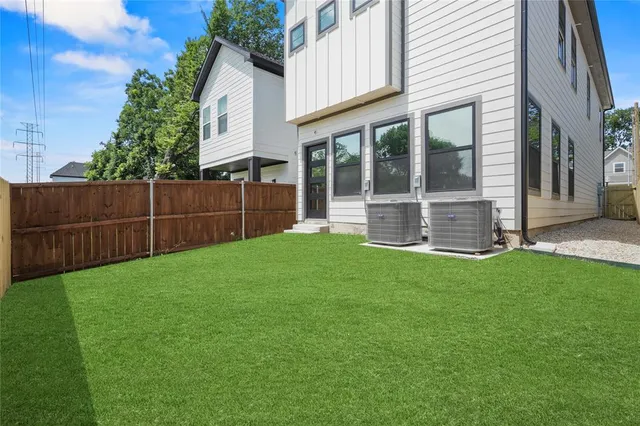 a view of a backyard with plants and large tree