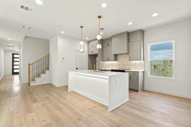 a large kitchen with kitchen island white cabinets and wooden floor