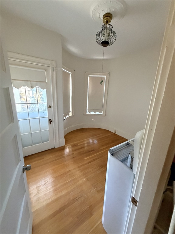 25 Congreve Street, Unit 2 Boston, MA 02131 - Photo 2 of 8 a view of an empty room with wooden floor and a window