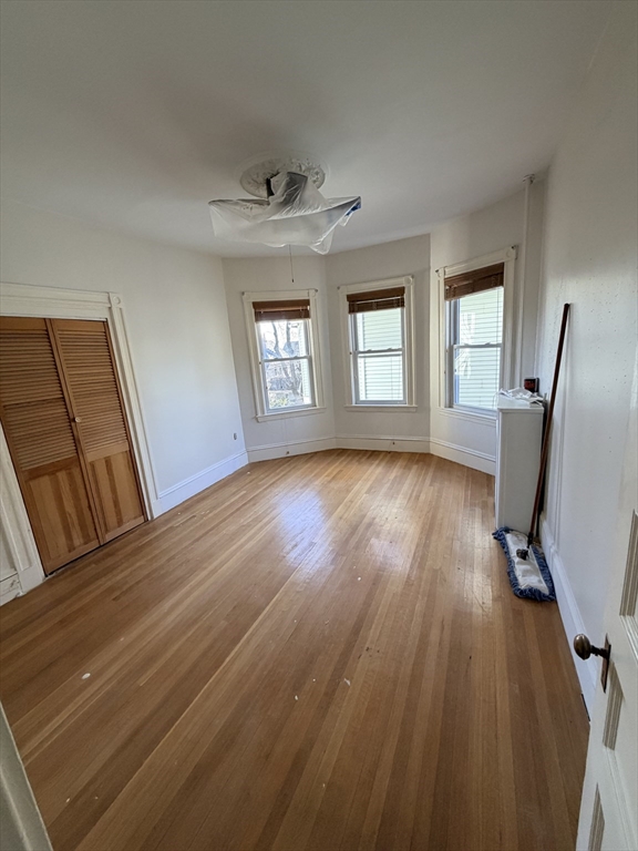 25 Congreve Street, Unit 2 Boston, MA 02131 - Photo 4 of 8 an empty room with wooden floor and windows
