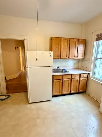 a kitchen with a refrigerator a stove top oven a sink and a window