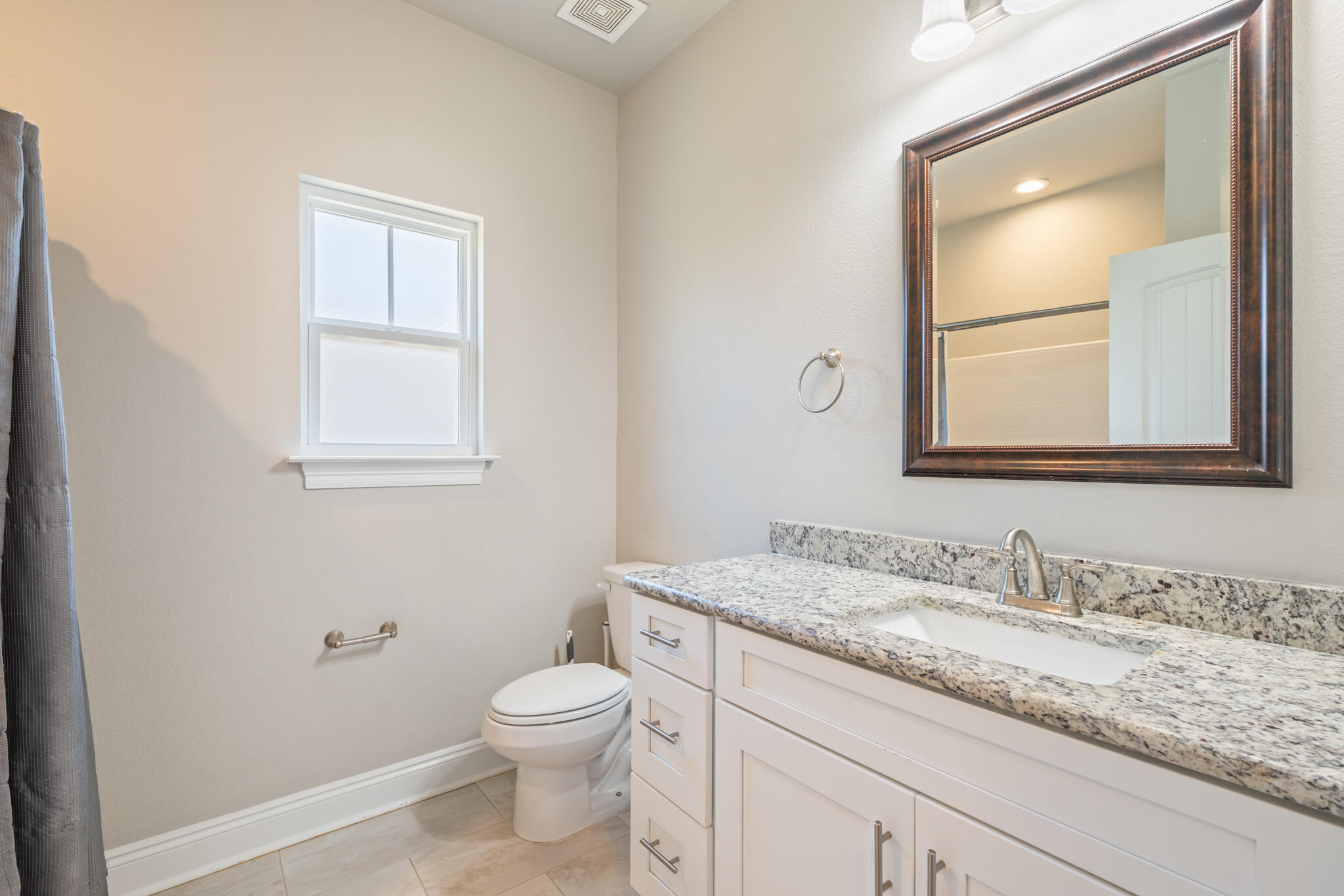 7287 Gordon Evans Road Navarre, FL 32566 - Photo 33 of 45 a bathroom with a granite countertop toilet a sink and mirror