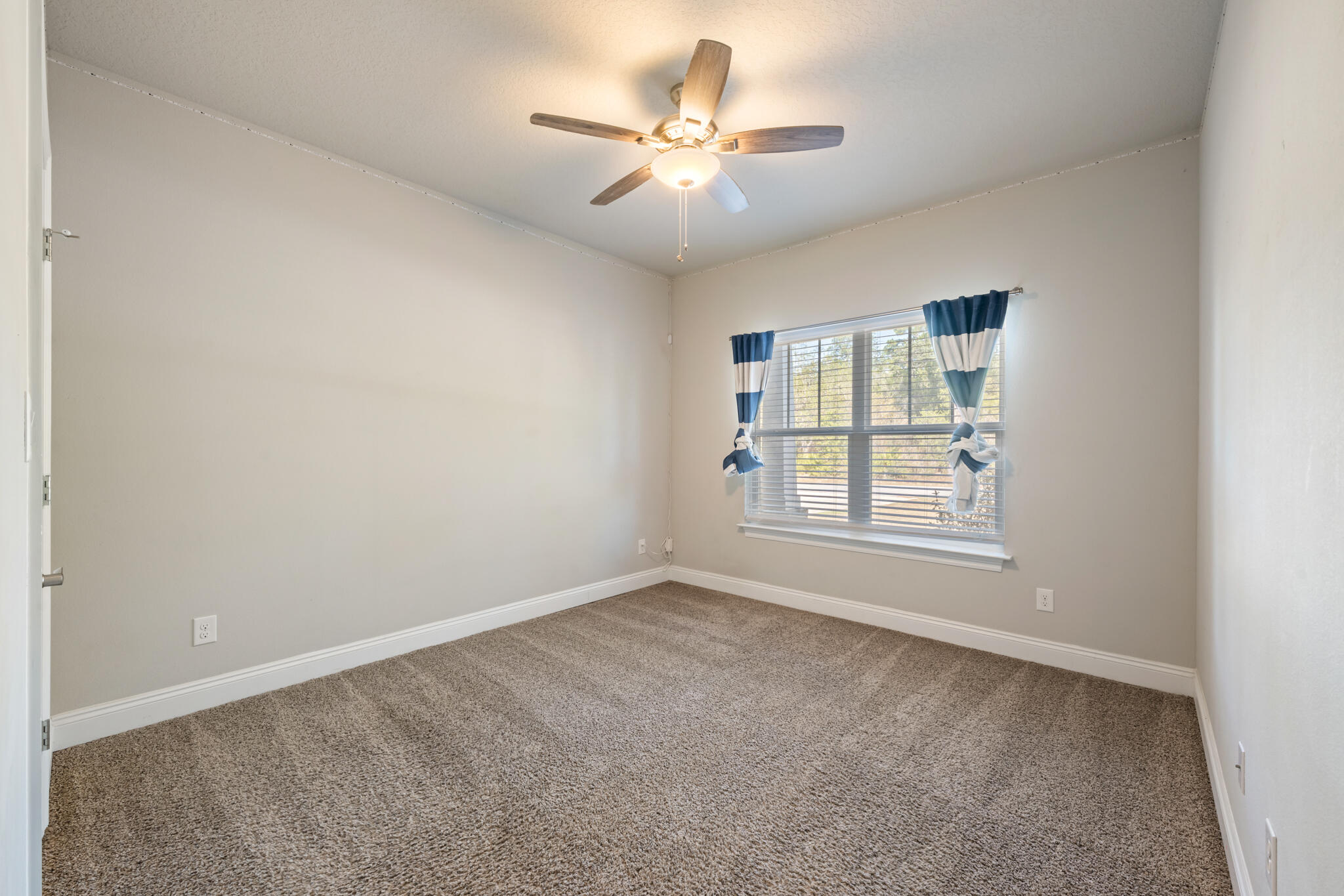 7287 Gordon Evans Road Navarre, FL 32566 - Photo 37 of 45 an empty room with windows and ceiling fan