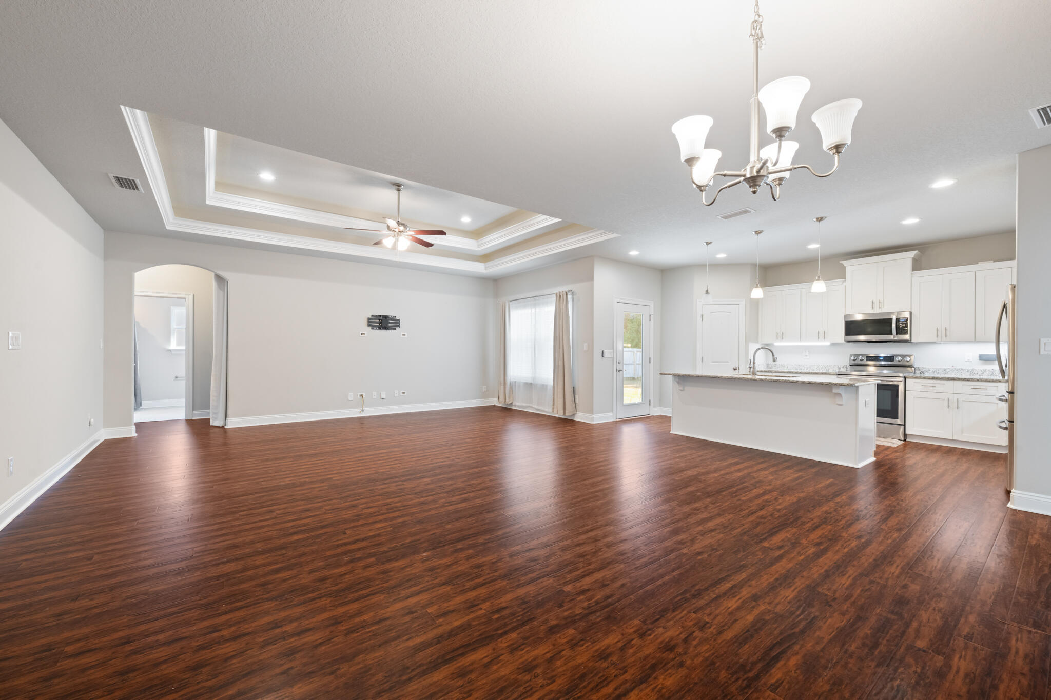 7287 Gordon Evans Road Navarre, FL 32566 - Photo 7 of 45 a view of a hallway with wooden floor and a kitchen