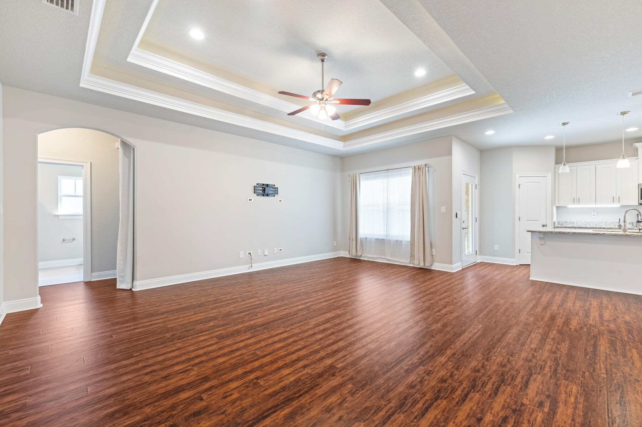 7287 Gordon Evans Road Navarre, FL 32566 - Photo 10 of 45 a view of an empty room with wooden floor and a kitchen view