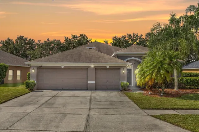 a front view of a house with a yard and trees