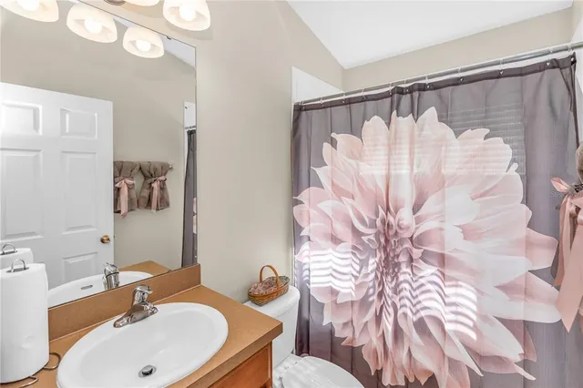 a bathroom with a sink and mirror with toilet