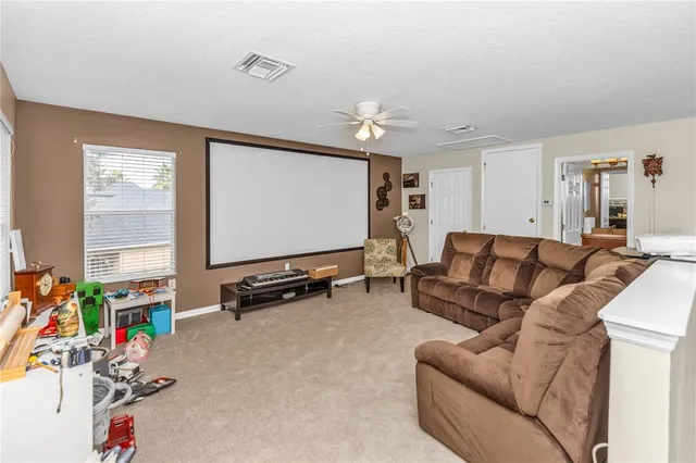 a living room with furniture a flat screen tv and a window