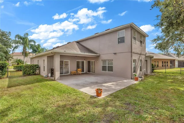 a view of a yard in front of a house with a large tree