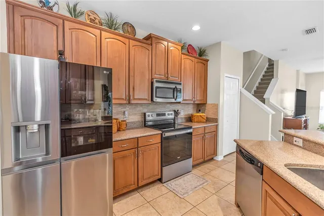 a kitchen with stainless steel appliances granite countertop a refrigerator sink and stove