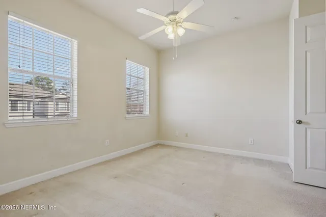 an empty room with a window and a fan