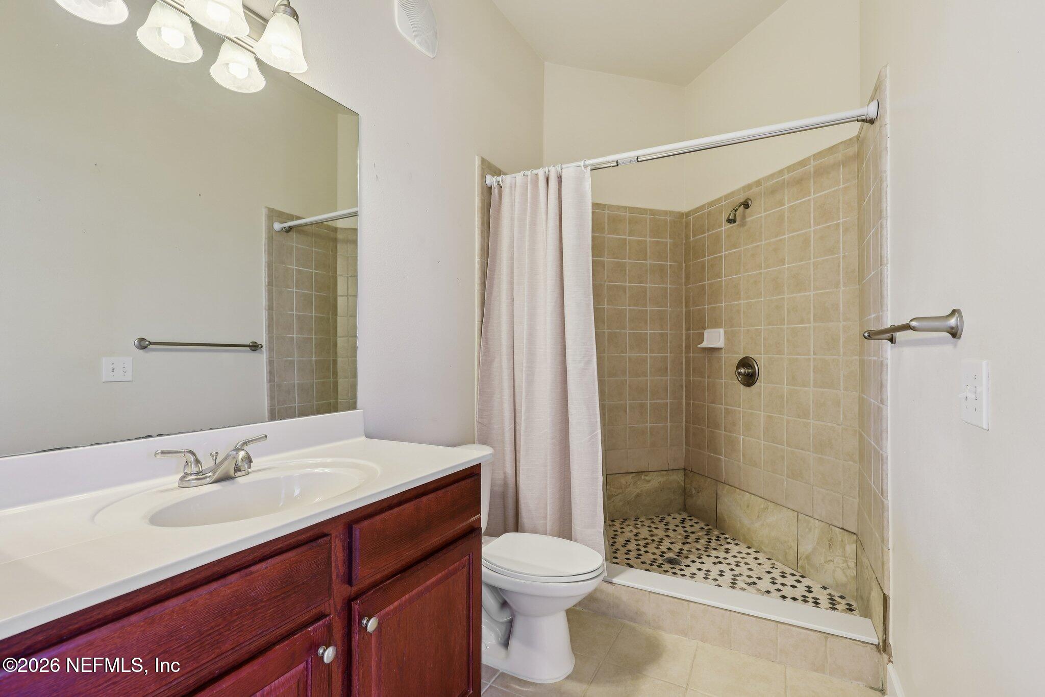 2035 Secret Garden Lane, Unit 505 Fleming Island, FL 32003 - Photo 23 of 47 a bathroom with a sink a toilet and shower