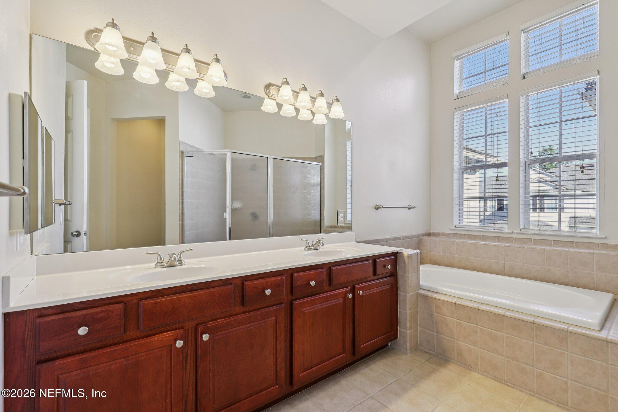2035 Secret Garden Lane, Unit 505 Fleming Island, FL 32003 - Photo 28 of 47 a spacious bathroom with a tub sink and mirror