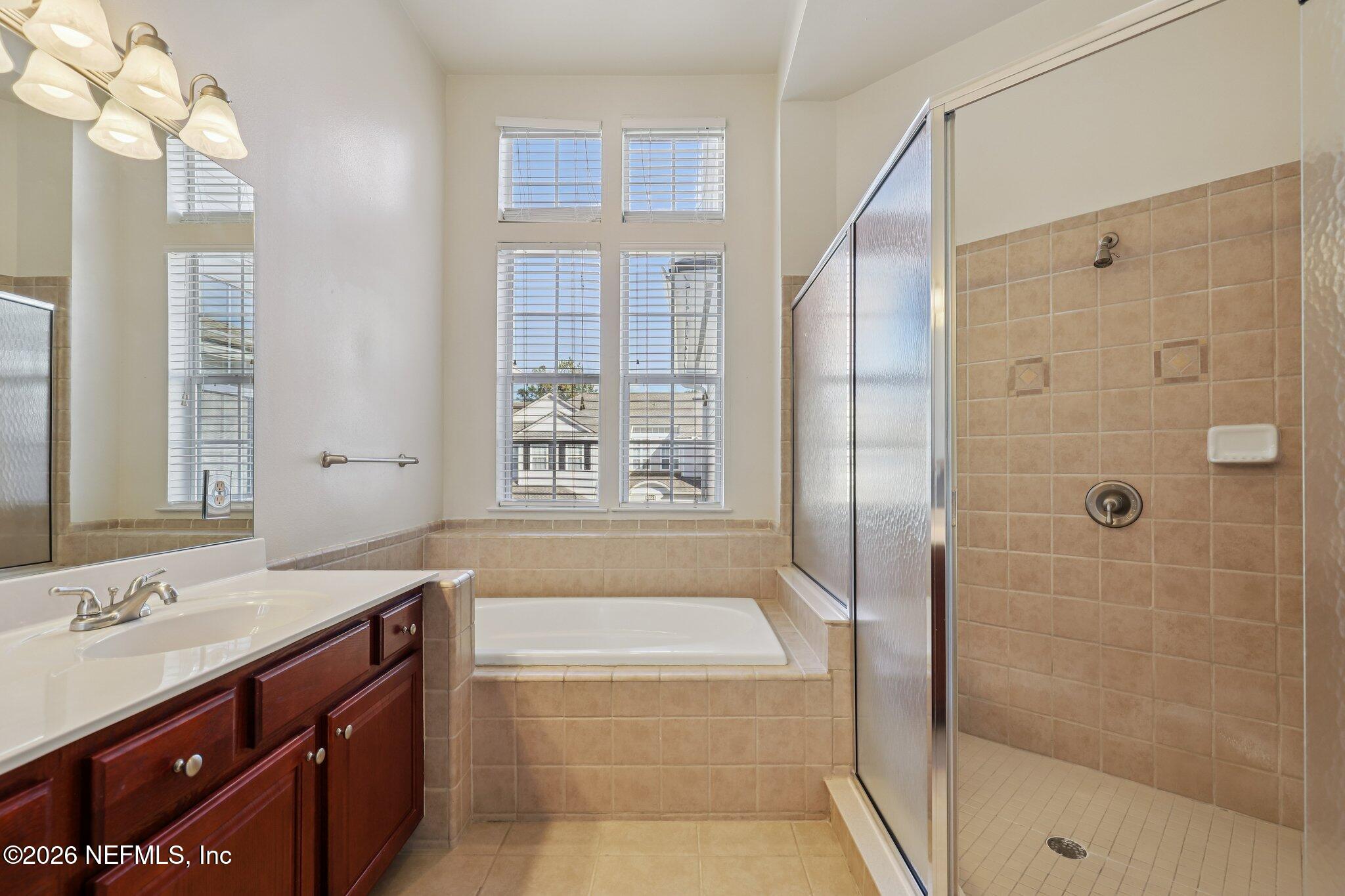 2035 Secret Garden Lane, Unit 505 Fleming Island, FL 32003 - Photo 29 of 47 a bathroom with a granite countertop sink a toilet a mirror and shower