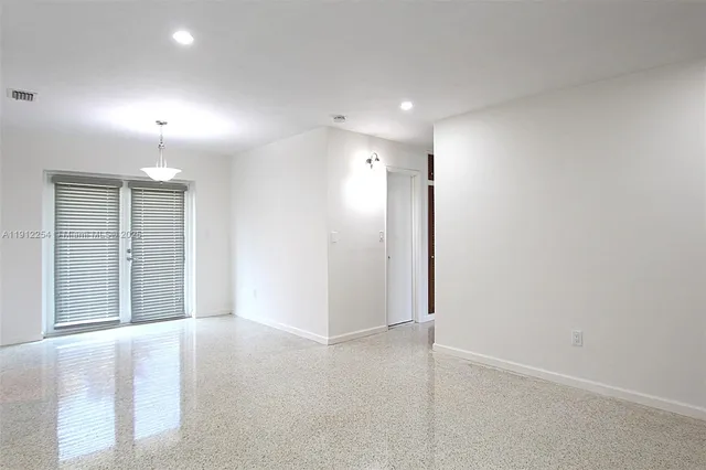 an empty room with windows and cabinet