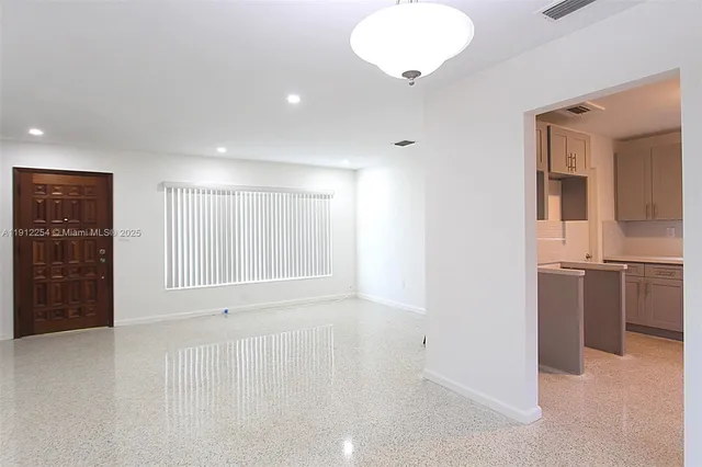 a view of an empty room with a kitchen