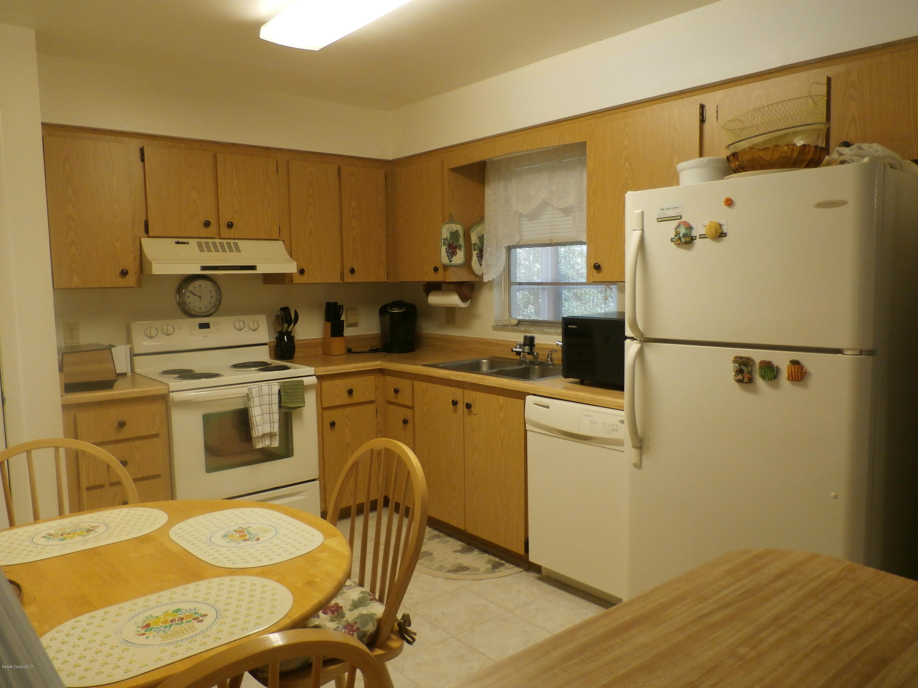 538 Trend Road West Melbourne, FL 32904 - Photo 8 of 16 a kitchen with a refrigerator a stove a sink dishwasher and white cabinets with wooden floor