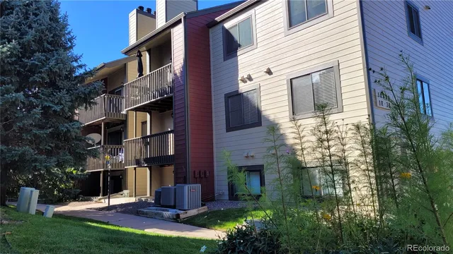 a view of a house with brick walls and a yard with plants