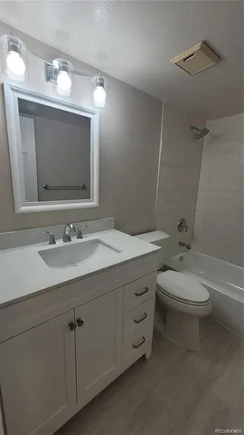 a bathroom with a toilet a sink a mirror and vanity