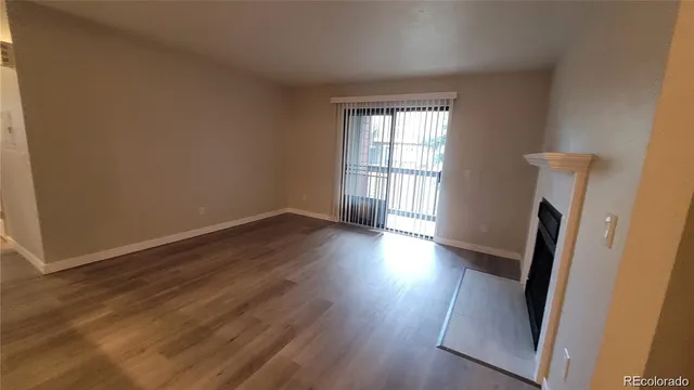 an empty room with wooden floor and a window