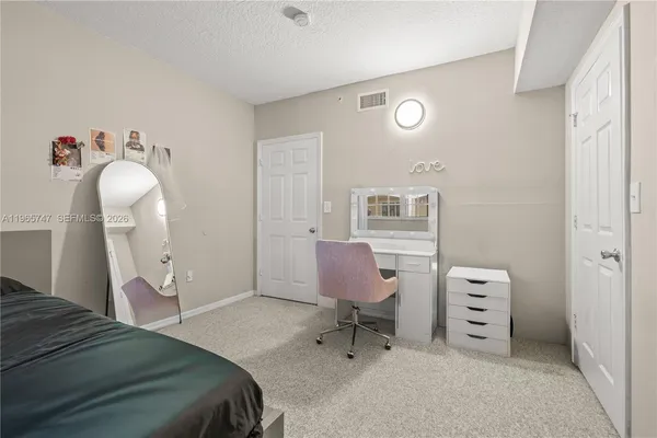 a bedroom with a bed a chandelier a mirror and a closet