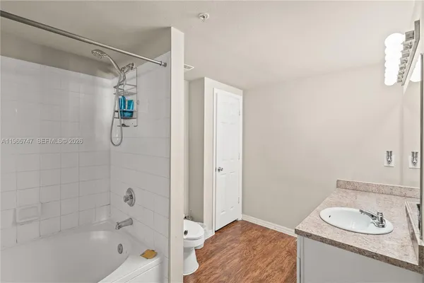 a bathroom with a tub shower sink and vanity