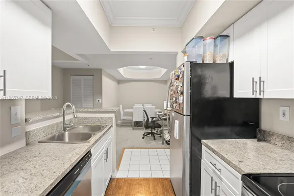 a kitchen with a sink a kitchen island a stove and a refrigerator