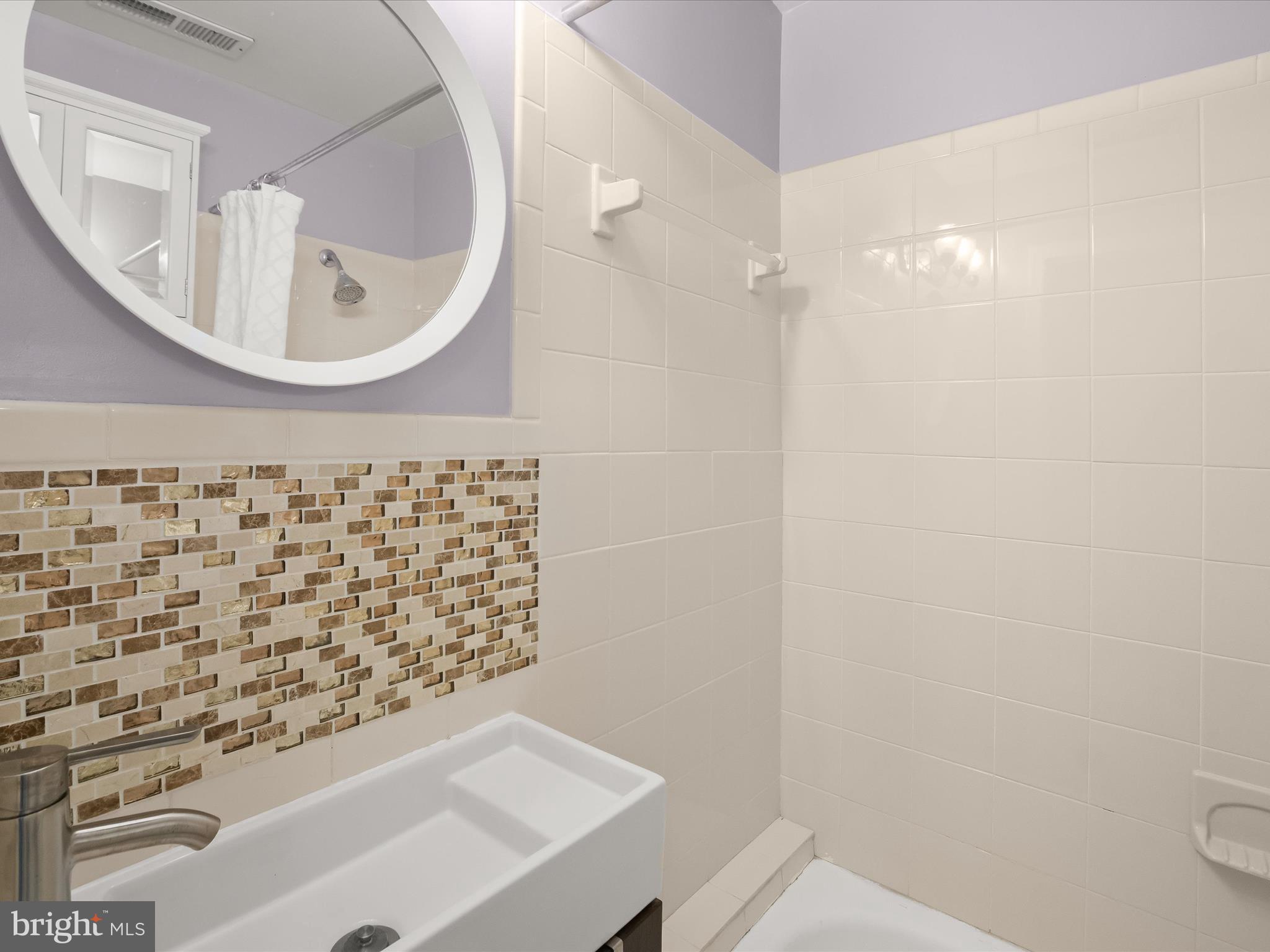 1648 Kramer Street Northeast Washington, DC 20002 - Photo 17 of 30 a bathroom with a sink a mirror and shower