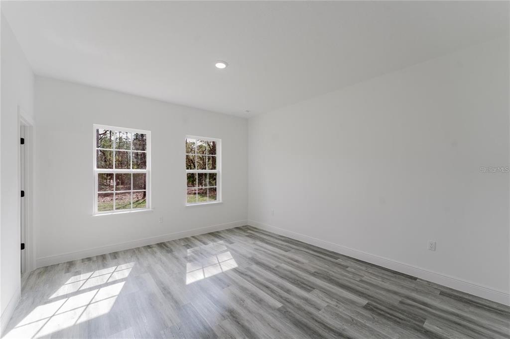 6732 Southwest 132nd Street Ocala, FL 34473 - Photo 24 of 36 a view of an empty room with wooden floor and a window
