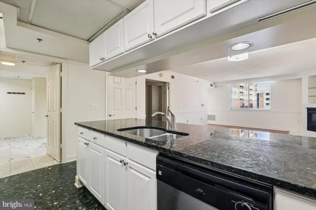 a kitchen with granite countertop a sink and cabinets
