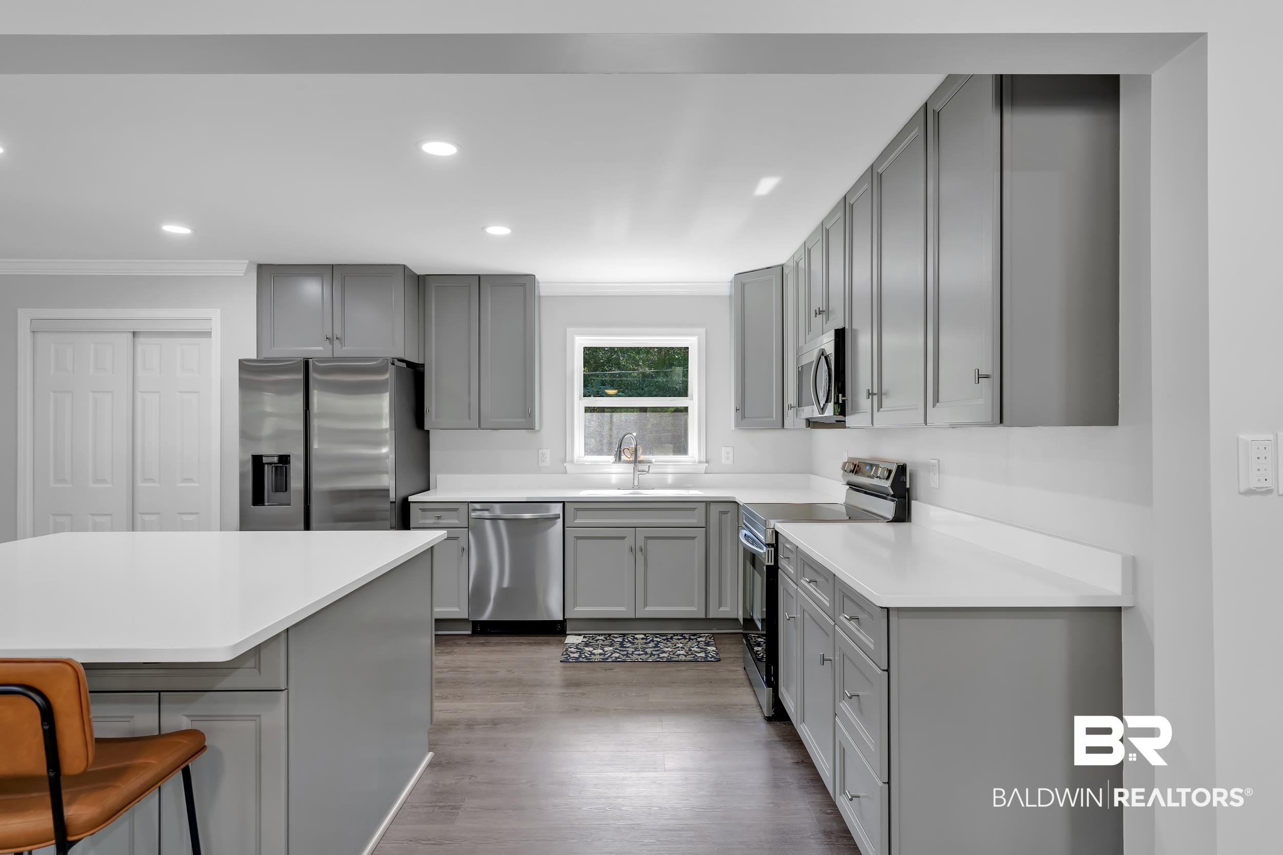 2712 Shelton Beach Rd Extension Mobile, AL 36613 - Photo 10 of 24 Kitchen featuring an island with a white countertop, coordinating grey cabinetry, stainless steel appliances, and wood-finish flooring