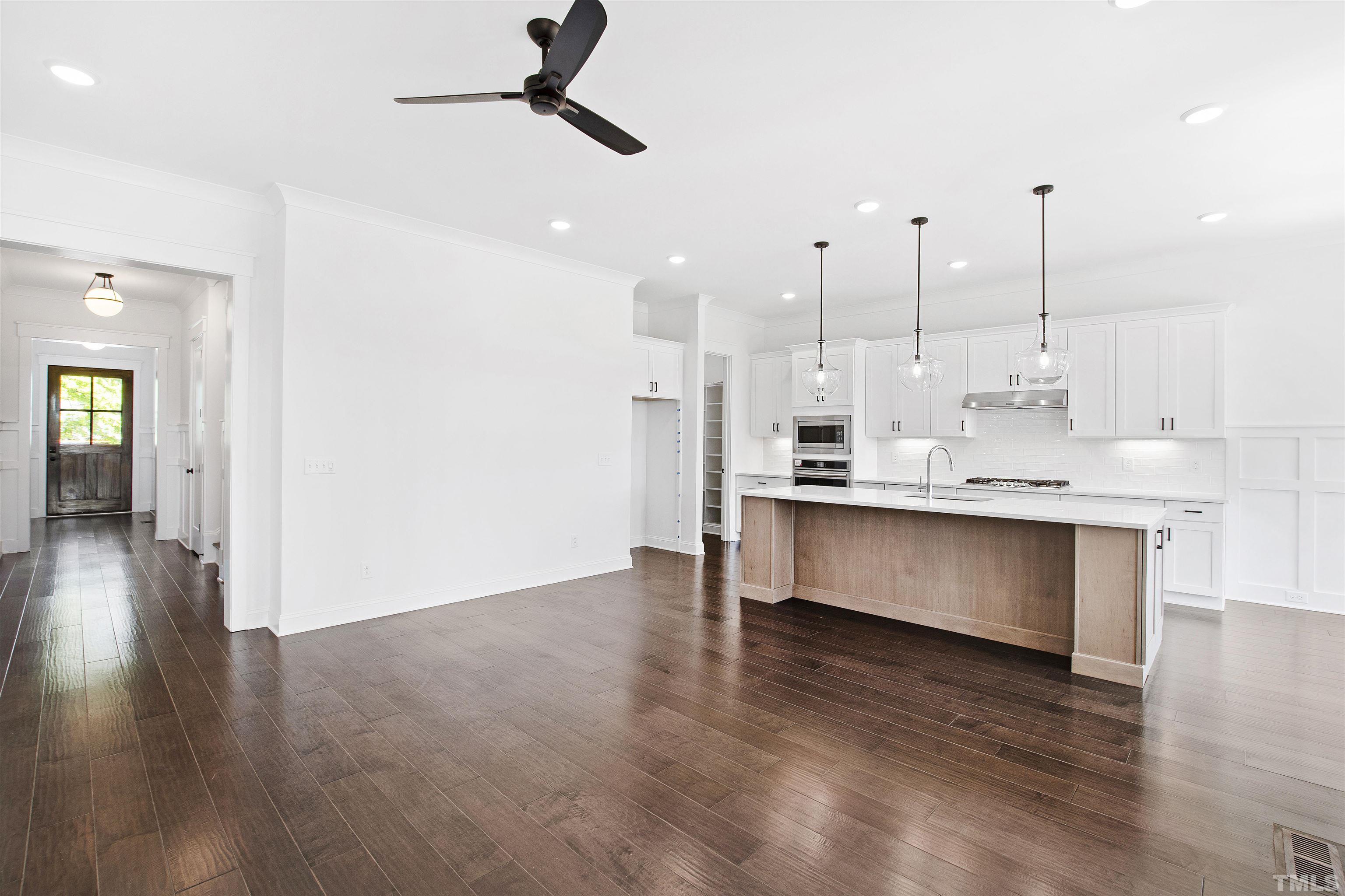 7528 Pinecrest Road Raleigh, NC 27613 - Photo 7 of 45 a view of kitchen with kitchen island stainless steel appliances a counter space and a ceiling fan