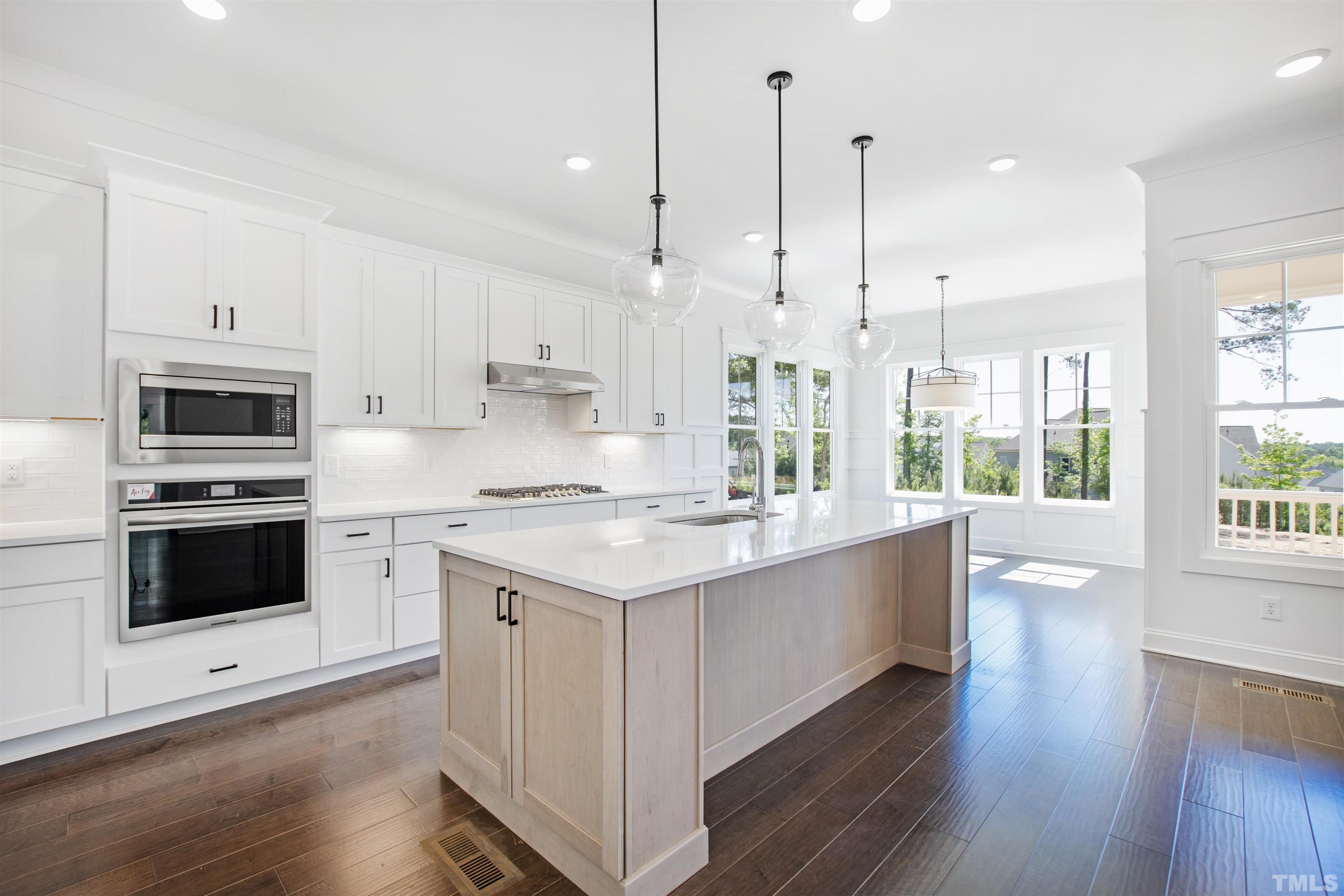 7528 Pinecrest Road Raleigh, NC 27613 - Photo 9 of 45 a large kitchen with stainless steel appliances and white cabinets