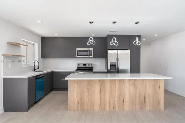 a kitchen with stainless steel appliances granite countertop a sink a stove and a refrigerator