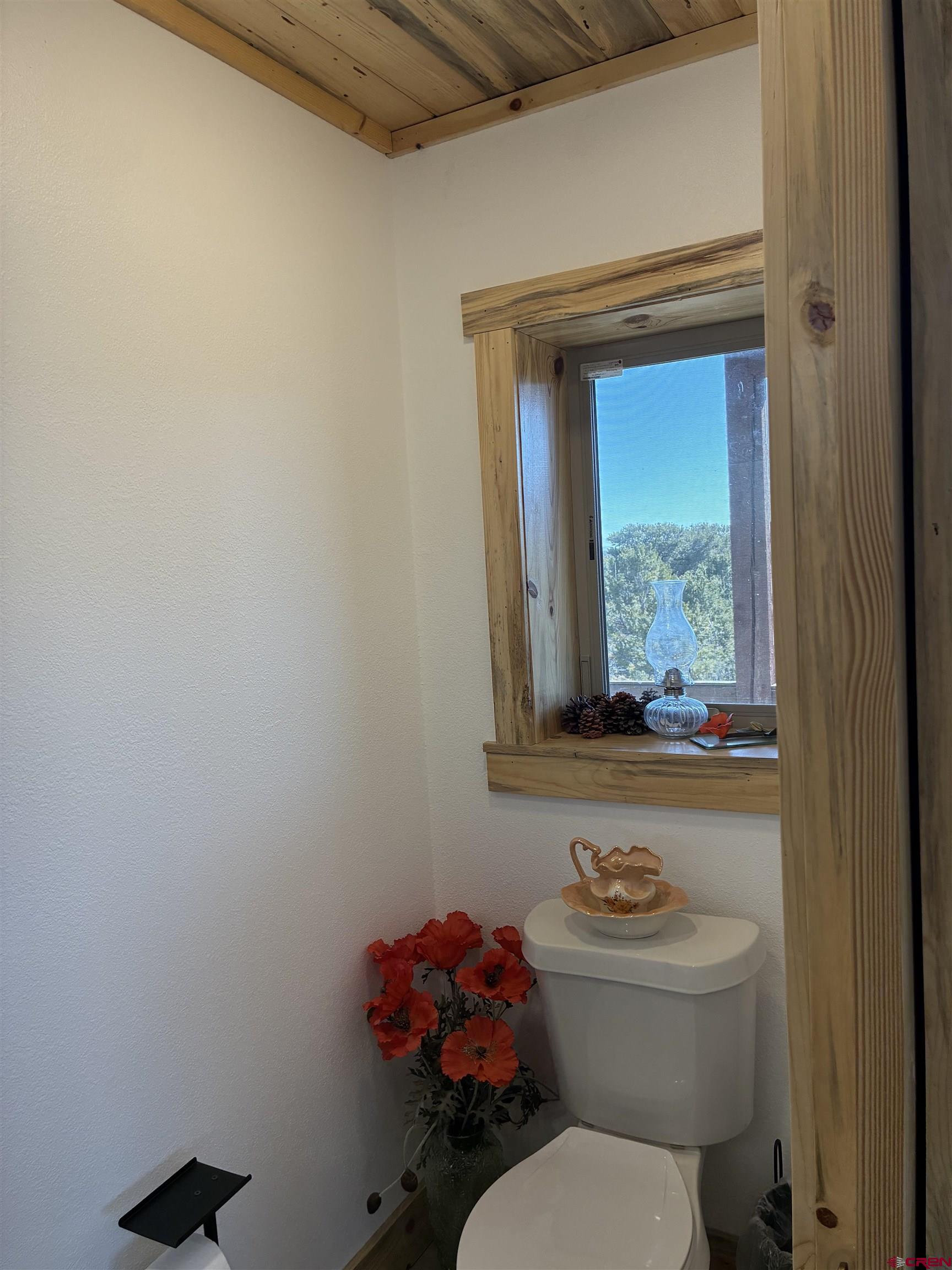 180 Boulder Lake Road Monte Vista, CO 81144 - Photo 11 of 35 a bathroom with a toilet a sink and a window