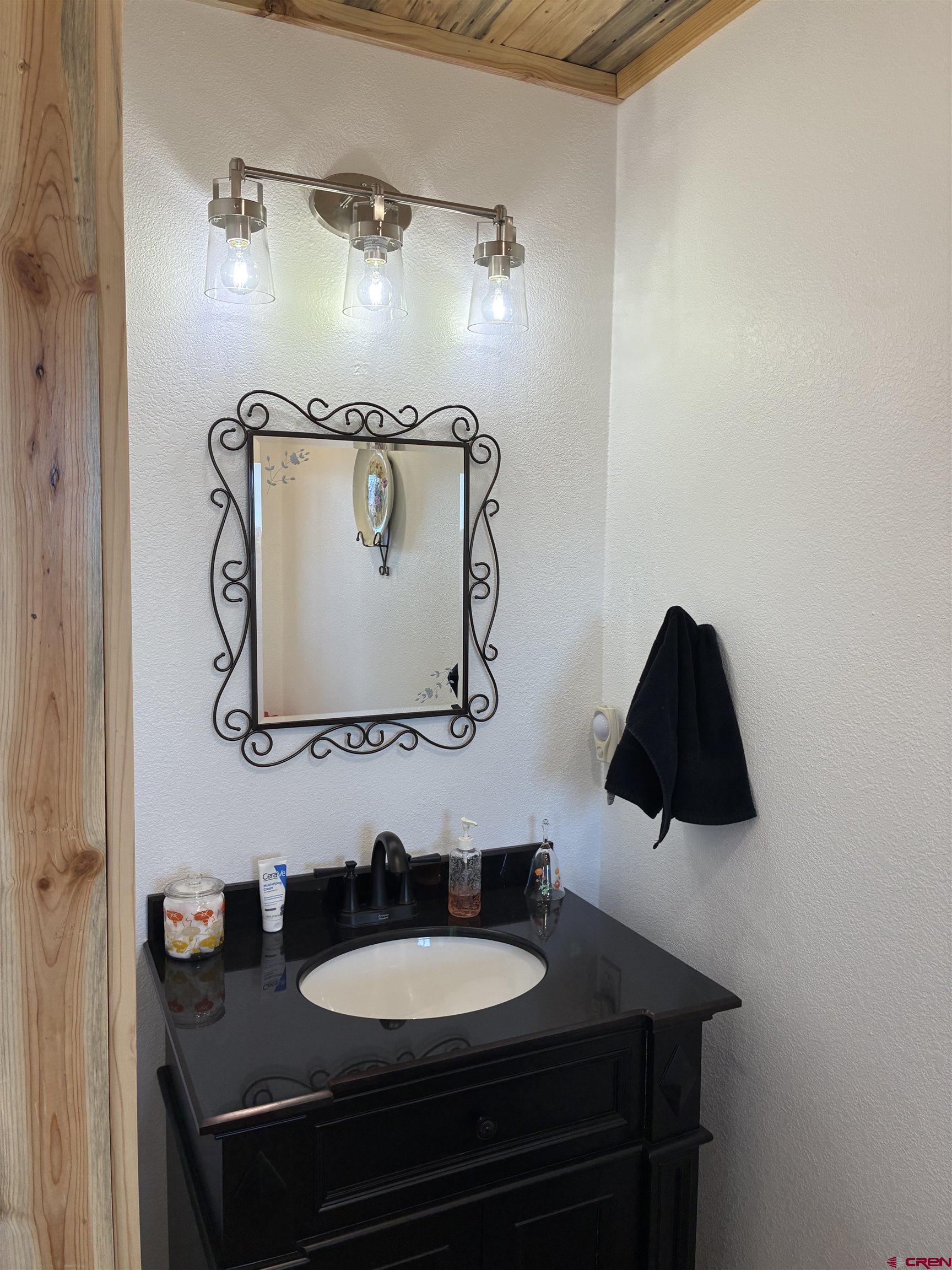 180 Boulder Lake Road Monte Vista, CO 81144 - Photo 12 of 35 a bathroom with a granite countertop sink and a mirror