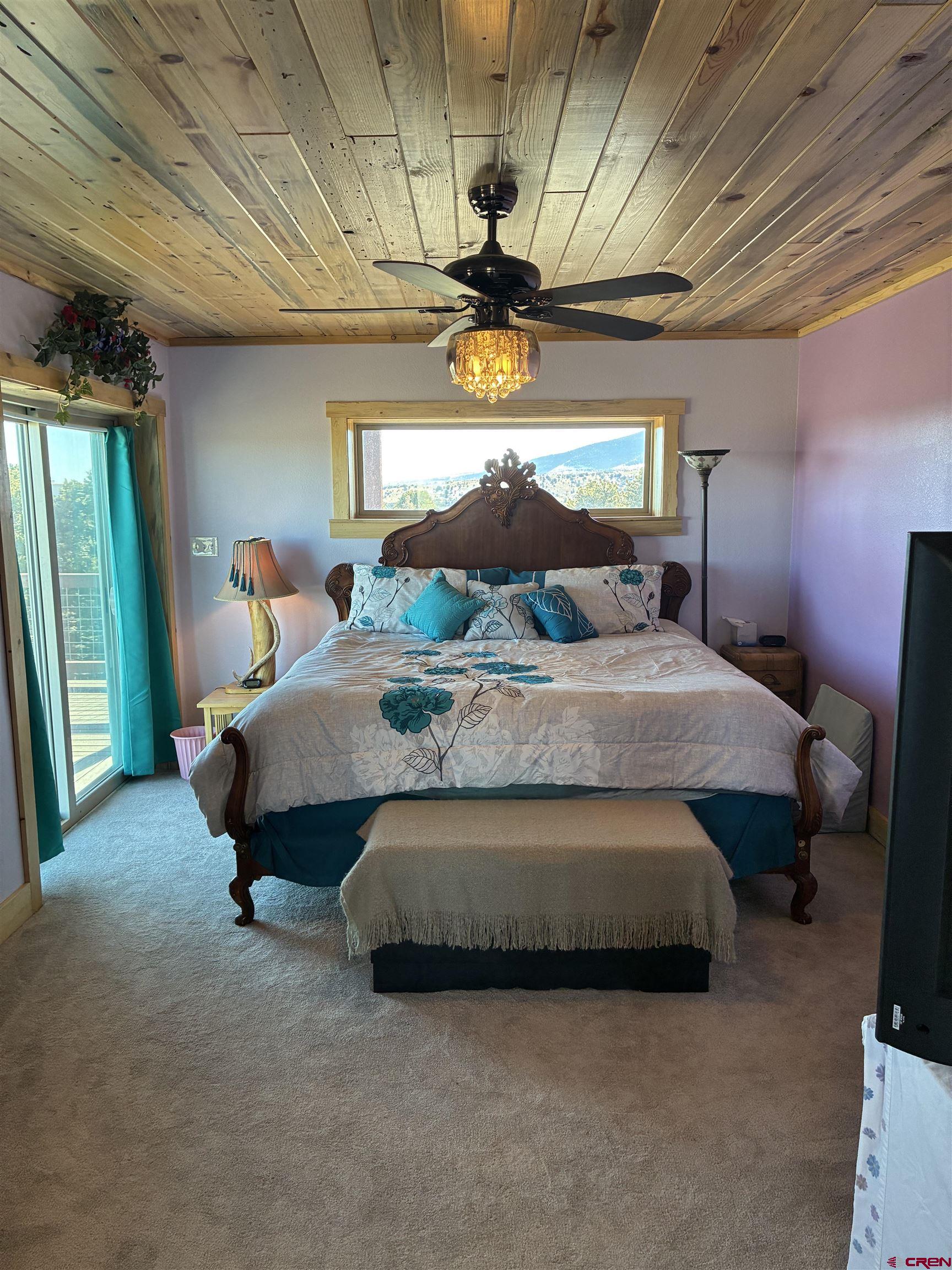 180 Boulder Lake Road Monte Vista, CO 81144 - Photo 13 of 35 a bedroom with a bed lamp and window
