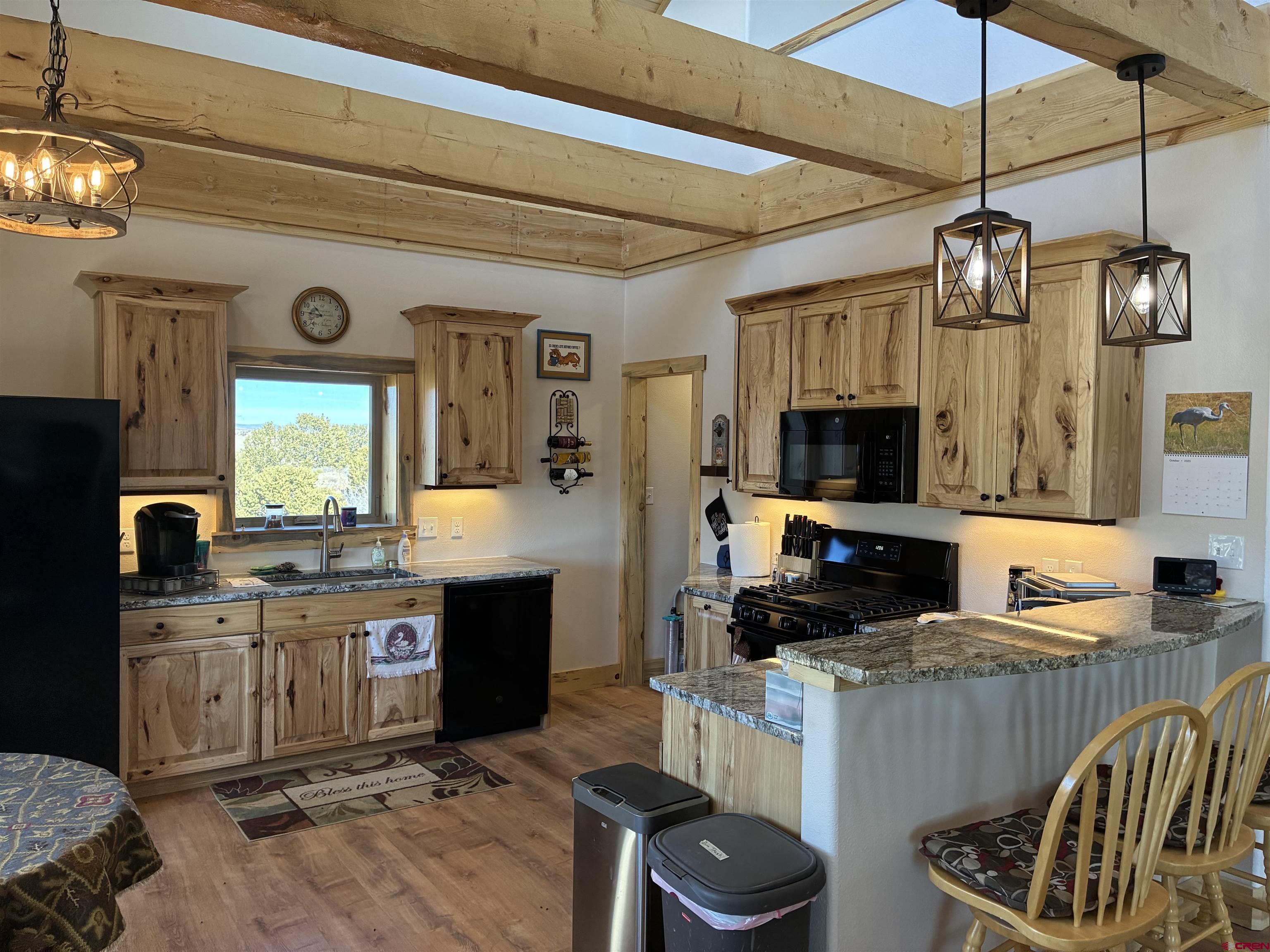 180 Boulder Lake Road Monte Vista, CO 81144 - Photo 8 of 35 a kitchen with stainless steel appliances granite countertop a sink a stove top oven a counter space and cabinets