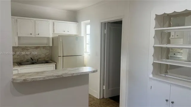 a kitchen with a stove and white cabinets