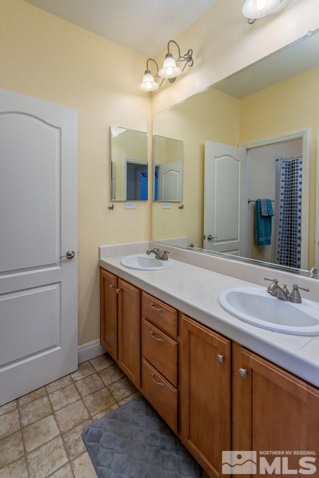621 Steeplechase Court Reno, NV 89521 - Photo 14 of 18 a bathroom with a granite countertop sink and a mirror