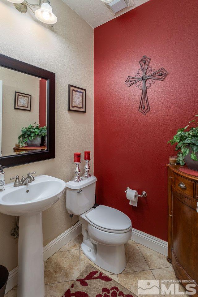 621 Steeplechase Court Reno, NV 89521 - Photo 9 of 18 a bathroom with a toilet sink and mirror