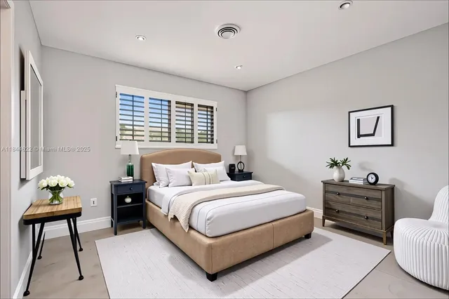 a bedroom with a bed window and a chair