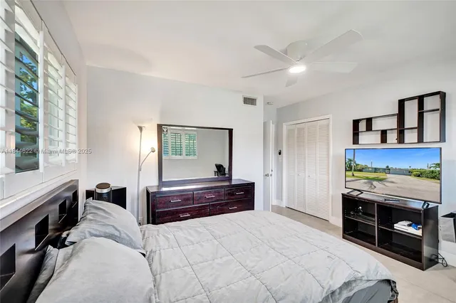 a bedroom with a bed and a dresser next to a window