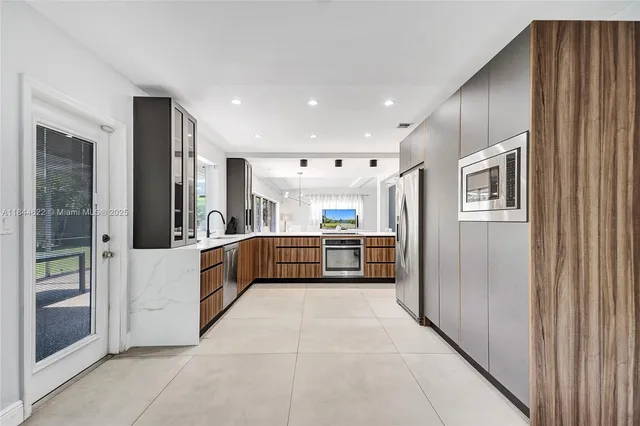 a kitchen with stainless steel appliances a sink and a refrigerator