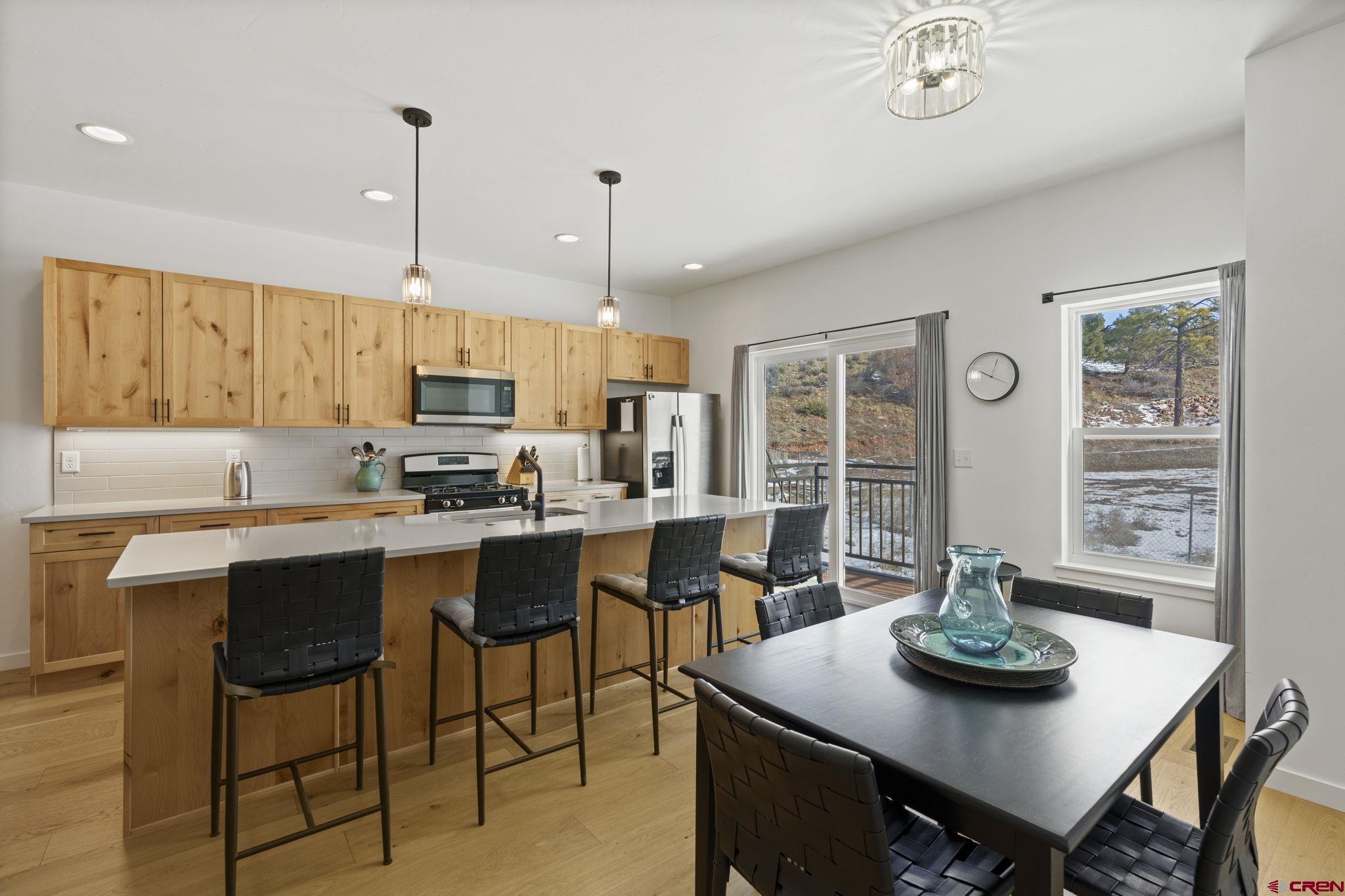 220 Metz Lane, Unit 603 Durango, CO 81301 - Photo 2 of 21 a kitchen with stainless steel appliances kitchen island granite countertop a table chairs and a refrigerator