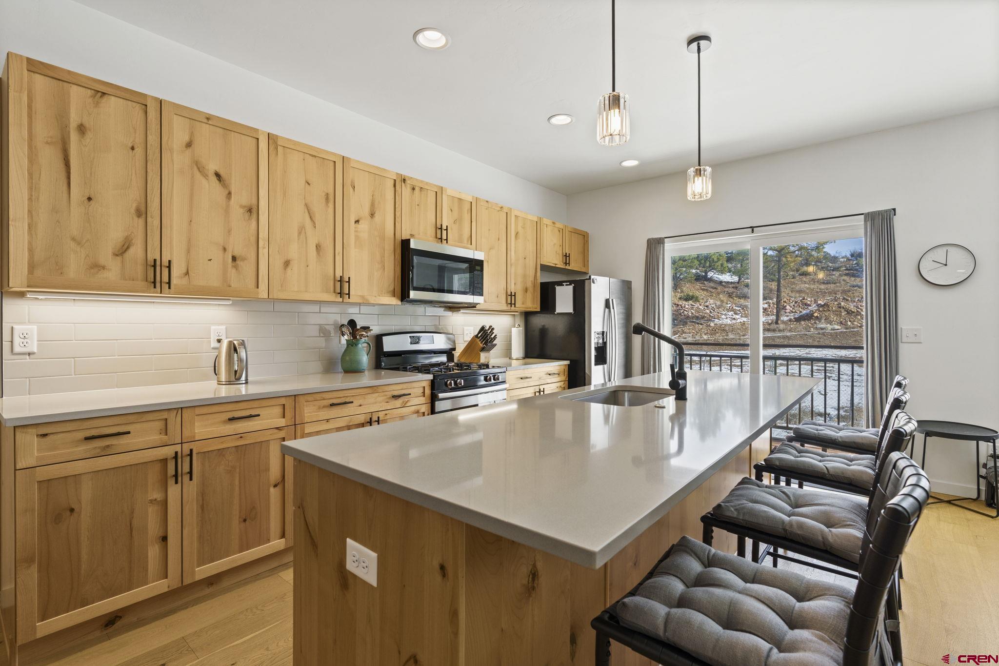 220 Metz Lane, Unit 603 Durango, CO 81301 - Photo 3 of 21 a kitchen with stainless steel appliances granite countertop a stove a sink a microwave a center island and furniture