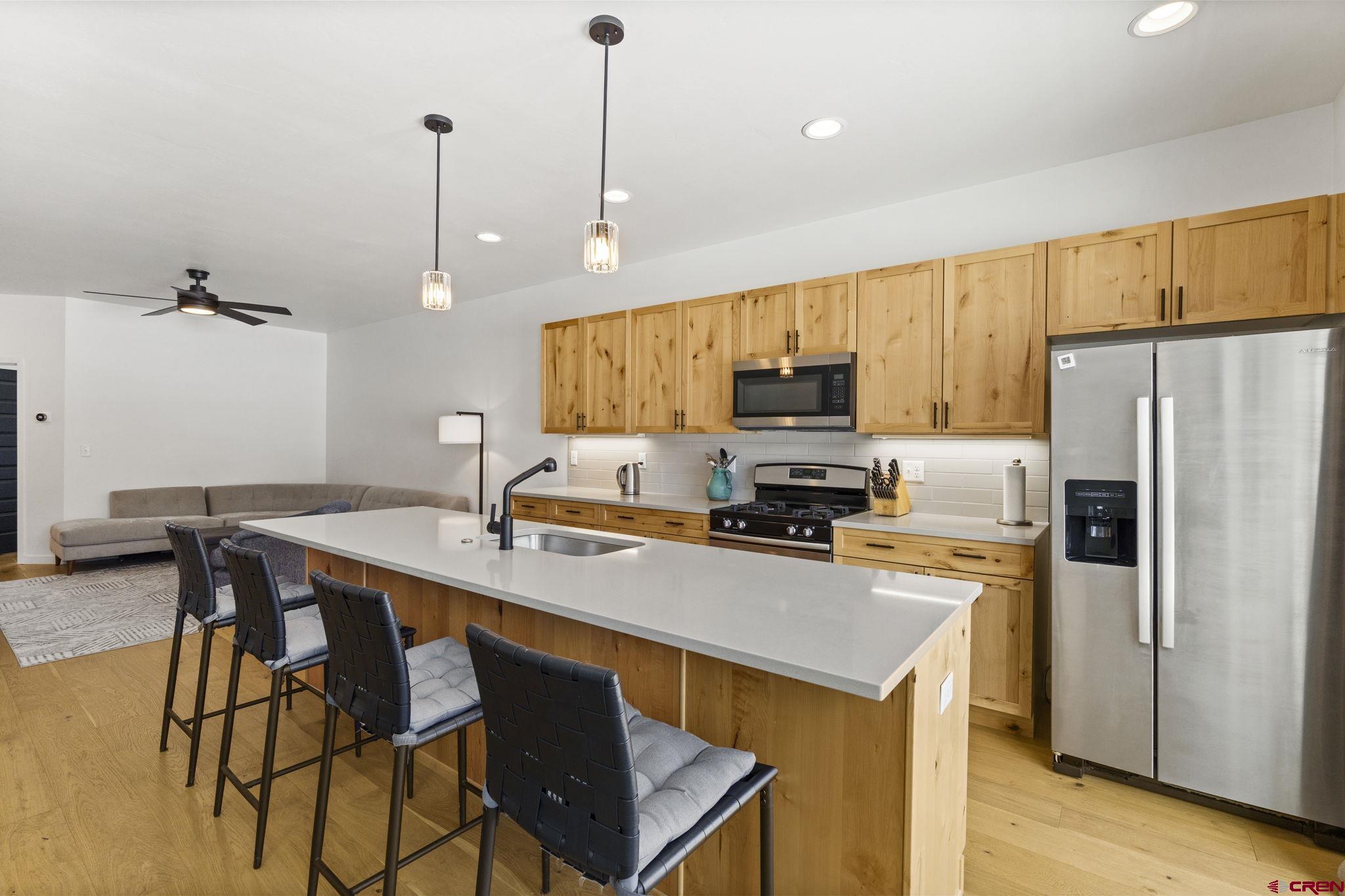 220 Metz Lane, Unit 603 Durango, CO 81301 - Photo 5 of 21 a kitchen with stainless steel appliances a stove a refrigerator a sink a stove with white cabinets and wooden floor
