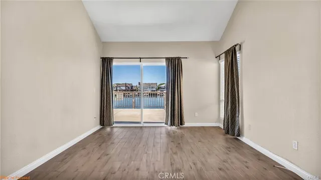 a view of a hallway with wooden floor windows and a living room